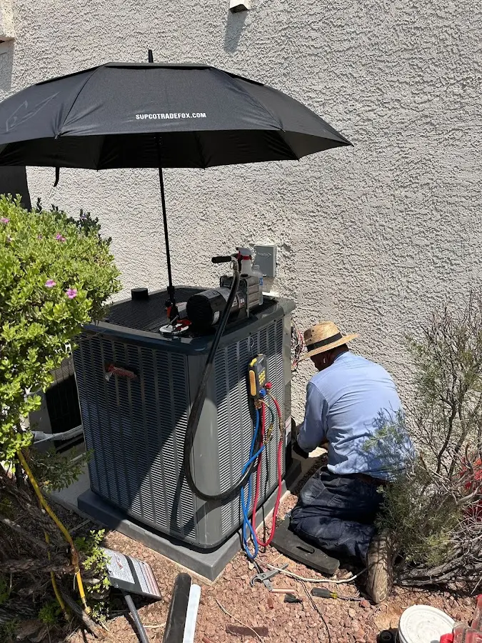 HVAC technician performing outdoor AC maintenance in Barre