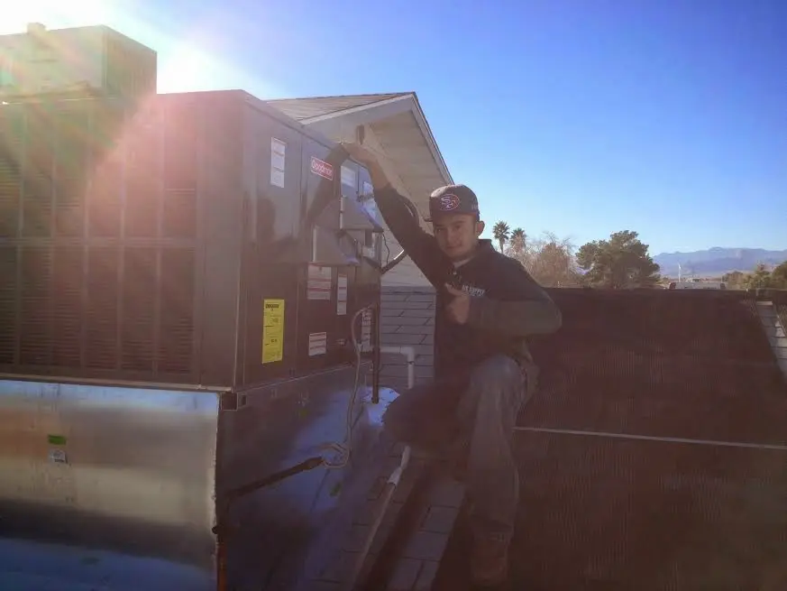 HVAC technician performing Air Duct Cleaning on a rooftop unit in Barre